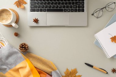 Serbest çalışma kavramını yansıtan başlıca görüntü, battaniye, kozalak, baharat, ofis malzemeleri, bardaklar ve sıcak çikolata eşliğinde bir dizüstü bilgisayar yakalıyor.