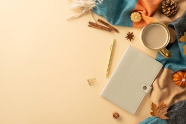 Sonbahar dokunuşlu mevsimlik masa konsepti. Sıcak kahvenin üst görüntüsü, deri kapaklı planlamacı, kırtasiye malzemesi, sıcak ekose, minyatür balkabağı ve diğer yumuşak bej arka plan, reklam için yer açmak.