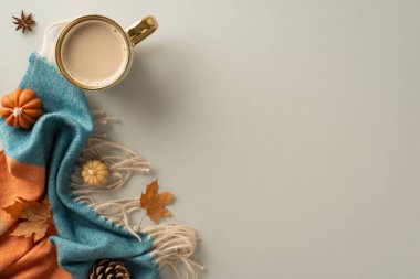 Evinizde sonbaharın sıcacık mutluluğunu deneyimleyin. Bu yukarıdaki manzaralı fotoğraf, yamalı battaniye, balkabağı mumları, akçaağaç yaprağı ve sıcak kakao kupası. Sahneyi gri arka planda mesaj ya da reklam için ayarlayın.