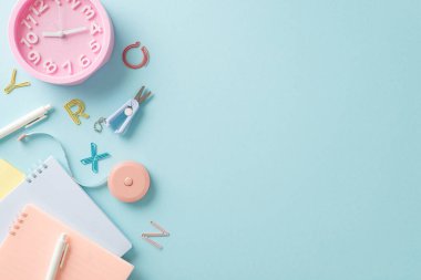 Öğrenme deneyiminizi, çeşitli okul malzemeleri, harf figürleri ve saat mavisi izole edilmiş arka plan içerikli bu tepeden tırnağa çekimle optimize edin.