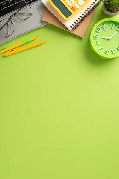 stock image Immerse yourself in the world of online education with this captivating vertical top-view image showcasing laptop, notepads and office supplies on light green backdrop. Perfect for text or advertising