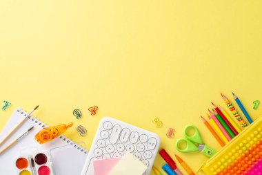 Klavye, sanat albümü ve izole edilmiş sarı arka planda bir sürü kırtasiye malzemesini gösteren bu yukarıdan aşağıya ekran görüntüsüyle uzaktan öğrenme olanaklarını araştırın. Metin veya reklamlar için telif alanını kullan