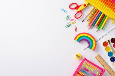 Küçük çocuklar için eğitimin sihrini bu yaratıcı üst görünüm fotoğrafıyla keşfedin: beyaz bir zemin üzerinde renkli çocuk kırtasiyeleri koleksiyonu, metin veya reklam entegrasyonuna hazır.