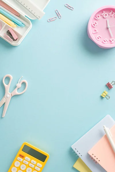 stock image Optimize your learning experience with vertical top shot featuring diverse assortment of school supplies, calculator and mini clock on blue isolated backdrop. Utilize empty circle for text or adverts