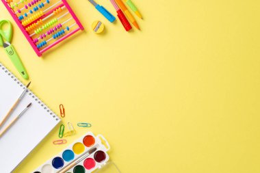 Yukarıdan alınan keyifli eğitim gereksinimleri: izole edilmiş sarı bir arka planda sergilenen canlı okul malzemeleri dizisi, metin veya tanıtım mesajları için telif alanı sağlar