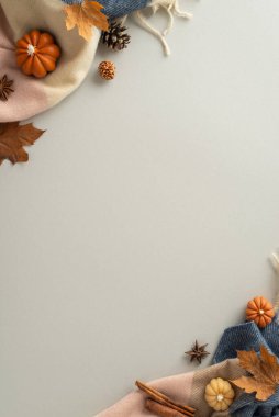 Sergilenen sonbahar hazineleri: Üzerinde tarçın çubukları, Çin anason, kozalak, akçaağaç yaprakları ve gri izole arkaplanda balkabağı şeklinde mumlar olan dikey manzara resmi, sergilenmek için mükemmel