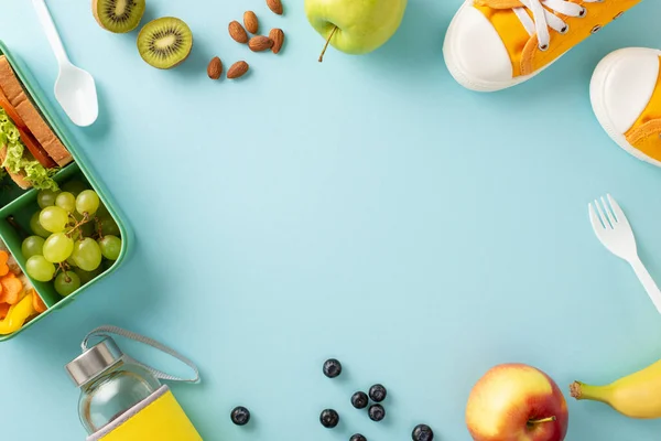 Revitalize your learning break: Top-down perspective highlighting lunch box packed with sandwiches, fruits, veggies and water bottle on pastel blue isolated backdrop, space for text or advertisements