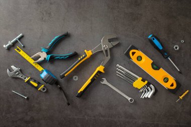 Amerikan İşçi Bayramı 'nda inşaat işçilerinin yorulmak bilmez çabalarını onurlandırmak. Grunge desenli gri betonun üzerindeki farklı inşaat malzemelerinin üstünde. Reklam veya metin için uygun