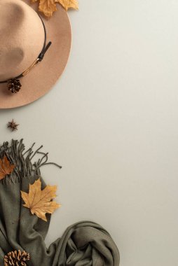 Klasik moda aksesuarları. Üst dikey görüntüde eski bir saat şapkası, zarif bir kaşmir eşarp ve büyüleyici açık gri bir arka plan var. Nostaljik damgalamak için mükemmel.