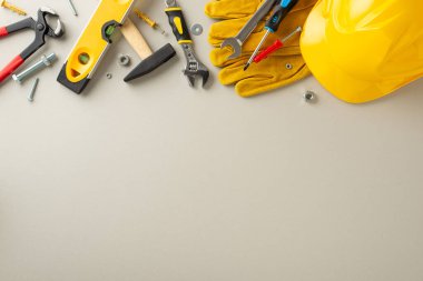 İşçi Bayramı 'nda inşaat işçilerine hürmet: inşaat malzemelerini ve açık gri zemine karşı araçları vurgulayan genel kompozisyon. İşçi Bayramı temalı reklamlar veya metinler için harika