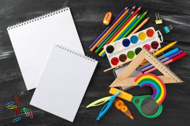 Erken eğitimin harikalarını bu tepeden tırnağa perspektifle araştırın: yazı veya reklam içeriği için boş albüm sayfaları sunan, tahta zemin üzerinde çocuk kırtasiyesinin büyüleyici bir düzeni