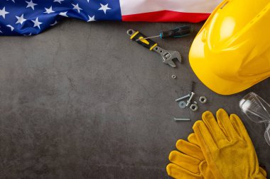 Amerikan İşçi Bayramı 'nda inşaat işçilerinin paha biçilmez katkılarına hürmet etmek. Bayrak, kask, eldiven ve teçhizat üzerinde gri beton desenli. Reklamlar veya metin için mükemmel
