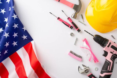 İşçi Bayramı 'nda kadın işçilerin etkisinin anısına. Amerikan bayrağını gösteren yüksek açılı fotoğraf ve beyaz izole edilmiş arka plan üzerinde reklam veya metin yerleştirme için telif alanı bulunan araçlar