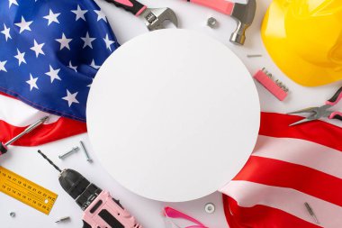 İşçi bayramında kadın işçilere saygılarını sunuyorlar. Beyaz izole edilmiş arka planda pembe bina ekipmanlarıyla birlikte bir Amerikan bayrağının üst görüntüsü. Reklamlar ya da metin yerleştirme için mükemmel