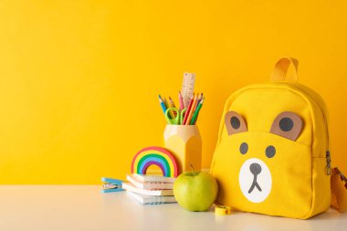 Eğitime mutluluk aşılayın. Canlı okul malzemelerinin, sarı izole edilmiş arka planda bulunan el yazması ve sırt çantasının, metin ya da reklam anonim şirketi için geniş bir alanla yan görünümü ile.