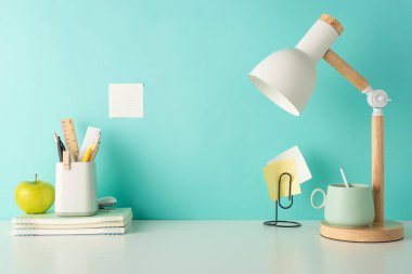 Okul gereçleri, kalem tutucu ve masa lambası ile birlikte, kolay metin veya reklam yerleştirme için tasarlanmış, mavi izole bir arka planda beyaz masaüstü bu yan görüş ortamı ile odaklanmış bir çalışma ortamı oluşturun