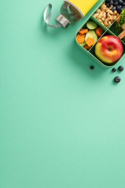 Baştan çıkarıcı ve sağlığa önem veren bir okul yukarıdan dikey kompozisyonu. Beslenme çantasında su şişeli ağız sulandırıcı sandviçler var. Metin ya da reklam için kopyalama alanı olan yalıtılmış deniz mavisi yüzeyinde.