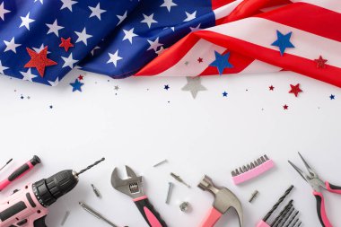 İşçi bayramında kadın işçilere saygılarını sunuyorlar. Beyaz izole edilmiş arka planda pembe bina araçlarıyla birlikte bir Amerikan bayrağının üst görünümü. Reklamlar ya da metin yerleştirme için mükemmel