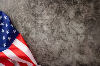 Resmi bayramı onurlandırmak: yukarıdan bakıldığında, grunge desenli gri beton arka planda Amerikan bayrağını gösteren görüntü. Festival vesilesiyle reklam ve metin örtüşmeleri için mükemmel.