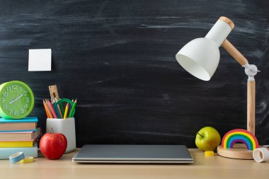 Bu öğrencinin çalışma ortamı ile akademik başarı elde edin. Bilgisayarın ve ofis malzemelerinin yan görüntüsü ahşap masa üzerinde izole edilmiş zemin üzerinde, metin veya reklam için fotokopi alanı sunuyor.