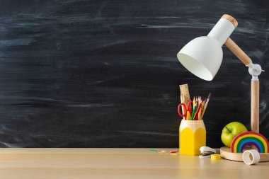 Bu öğrencinin iş yeri konseptiyle mükemmel bir çalışma alanı oluşturun. Yan görünüm fotoğraf kabartma masa lambası, ahşap masa üzerindeki kırtasiye karatahta izole edilmiş arka plan, metin veya reklam için alanı olan