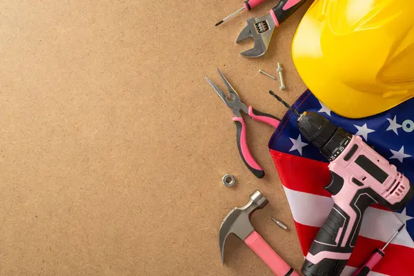İşçi Bayramı 'nda kadın işçilerin önemli rolünü onurlandırmak. Üst görünüm, reklam veya metin için telif alanı bulunan kontrplak zemin üzerinde inşa araçlarıyla birlikte bir Amerikan bayrağını yakalıyor.