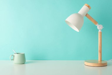 Öğrenci işyerinin bu yan görüş görüntüsüyle çalışma verimliliğini artırın, beyaz masa lambası ve fincanı pastel deniz mavisi izole arka planda, metin veya reklam dahil etme için mükemmel