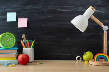 Öğrencilerin etkin öğrenim alanları. Masa lambası, durağan ve kitapların karatahta üzerindeki yan görünüm fotoğrafı metin veya reklam için kopyalama alanı olan izole edilmiş arkaplan