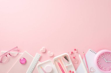 Liseli kızın yaratıcı gereksinimleri. Kağıt ve malzemelerin üst görünümü: kalem kutusu, kalem kutusu, silgi, kalp şeklinde klipler, gözlük ve daha fazlası açık pembe arka planda, eğitim içeriğini desteklemek için ideal