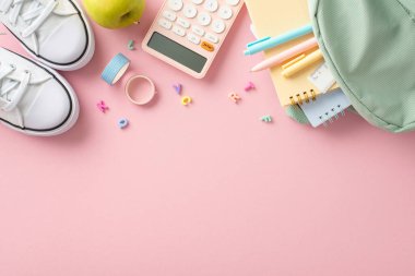 Modaya uygun eğitim teçhizatı düzenleme. Kalem, cetvel, yapışkan bant, defter, alfabe harfleri, hesap makinesi, ayakkabı, yumuşak pembe zeminde elma, yazı veya tanıtım için alan içeren sırt çantasının üst görünümü