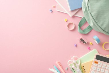 Zarif kadınsı öğrenme materyalleri bileşimi. Adaçayı rengi çanta, kalem, zımba, bant, makas, not defteri, alfabe harfleri, metin veya reklam için yeri olan pastel pembe yüzey üzerinde hesap makinesi.