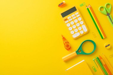 Bu öğrencinin çalışma düzeniyle verimliliği arttır. Parlak sarı izole arkaplan üzerinde hesap makinesi ve diğer kırtasiye resimlerinin üst görünümü, metin veya reklam için geniş bir kopya alanı sağlar