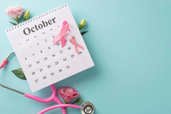 A date with health: plan an October doctor\'s appointment for breast cancer awareness with this top view. Pink ribbons, stethoscope express vigilance, while eustoma flowers embellish light blue setting