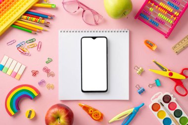 Sanat atölyesi teması. Çeşitli sanat materyallerinin üst görünümü: eskiz kitabı, suluboya palet, klipler, el yapımı makas, kalem açacağı, abaküs, akıllı telefon ve mesaj için yeri olan pembe yüzey üzerinde daha fazlası