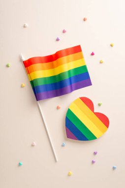 LGBT temalı aksesuarlarla düz konumda yatıyordu. Gökkuşağı bayrağı, büyük kalp ve bej arka planda küçük dekoratif kalpler de dahil.