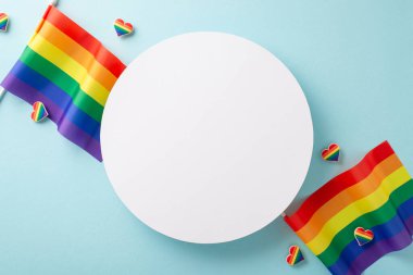 Temmuz ayındaki LGBTQ + topluluğunun gurur ayı. Açık mavi izole arkaplandaki lgbq + bayraklarının ve gökkuşağı kalplerinin reklam veya metin mesajları için fotokopi alanı ile yüksek açılı görüntüsü