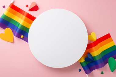 Temmuz 'u LGBTQ + Gurur Ayı olarak kutlayın. Renkli kalpler ve LGBTQ + bayraklar içeren, pastel pembe izole bir zemin üzerinde tutuklayıcı bir üst görünüm kompozisyonu. Reklamlar ve metinler tam uyuyor