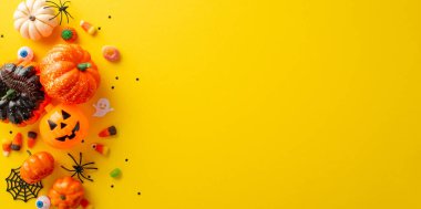 Eğlenceli çocukların şeker mi şaka mı geleneği. Şekerli bir balkabağı resmi ve sarı izole bir zemin üzerinde Cadılar Bayramı süslemeleri, metin veya reklam için kopyalama alanı sağlar