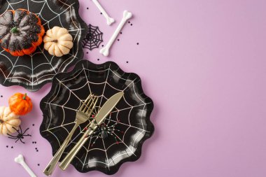 Ürkütücü Cadılar Bayramı masa düzenlemesi: üst manzara ürkütücü cazibeyi yakalar. Yenilikçi sofra takımı, örümcek ağı tabakları, balkabağı aksanları, tüyler ürpertici sürüngenler, kemikler, konfeti süsleyen leylak arkaplan. Mesajın için mükemmel.