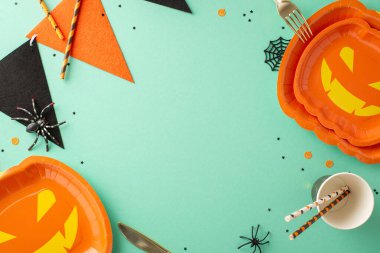 Cadılar Bayramı masa örtüsü ile partinizi değiştirin: üst görünüm kriko-fener tabakları, çatal bıçak takımı, kağıt bardak, pipet, örümcekler, çelenkler ve konfeti gibi ürkütücü dekorlar. Metin veya promosyonlar için Teal ayarı