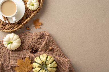 Sonbahar konfor titreşimi yakalanır. Üst manzara sıcak kahverengi örgü, buharlı kahve fincanı hasır sepetinde, meşe palamudu, tarçın, akçaağaç yaprağı, ve yumuşak bej arka planda köfte. Metin veya reklamlar için boşluk