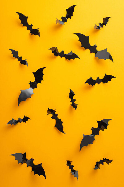 Захватите суть вашего Хэллоуина события. Вертикальный вид летучих мышей на желтом фоне, предлагающий пространство для формулировки или объявления