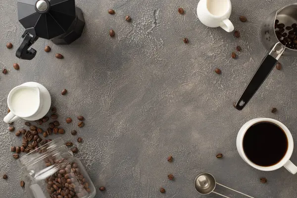 Caffeine Love: Coffee Day concept with coffee beans, espresso cup, cream and milk jars, coffee turk, barista\'s spoon, and kettle beautifully arranged on a dark grey grunge background with frame for ad
