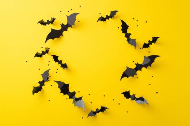 Cadılar Bayramı 'nın gece korkularını hisset. Resmin üstünde siyah kağıt yarasalar ve konfeti yıldızlarının sarı izole yüzey üzerinde bir daire gösteriliyor, metin veya reklam görevlileri için uygun.