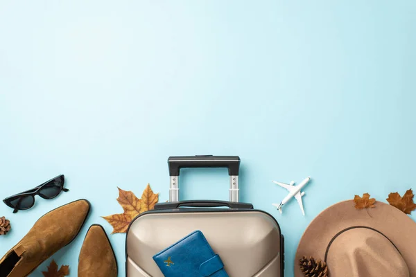 stock image Your autumn journey, your elegance. Top-down view featuring a gray suitcase with passport, trendy boots, chic sunglasses and felt hat on light blue isolated backdrop, ready for your travel message