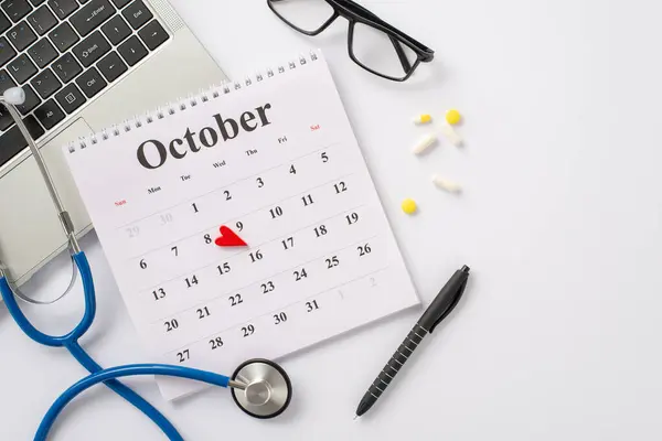 Virtual doctor appointment concept. Laptop, stethoscope, calendar with highlighted 8th of October, glasses, pen, pills displayed from top view on white background with space for text or promotion