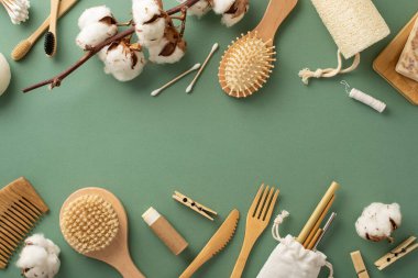 Dünya dostu esaslar. Bambu diş fırçalarının, tahta kamışların, lif bezlerinin, saç fırçalarının, mandalların ve yeşil yüzeyde daha fazla çevre dostu eşyanın genel manzarası, markalaşmaya hazır.