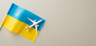 Köprüleme sınırları: Ukrayna ve uçak modelinin ulusal bayrağının metin veya tanıtım mesajı için boş alanı olan yumuşak gri bir tuval üzerindeki görsel temsili