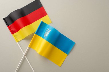 Ukrayna ve Almanya 'nın birliğini, ulusal bayraklarını ince gri bir yüzey üzerinde gösteren üstten bir fotoğrafla ifade etmek. Metnin ya da reklamın için boş bir tuval
