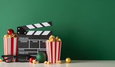 Süslü film galası nefis atıştırmalıkların altını çiziyor. Yan manzara masası film yapımcısının alkışı, 3D gözlükler, konteynırlarda patlamış mısır, film reklamları için yeşil duvara yapıştırılan süslemelerle süslenmiş.